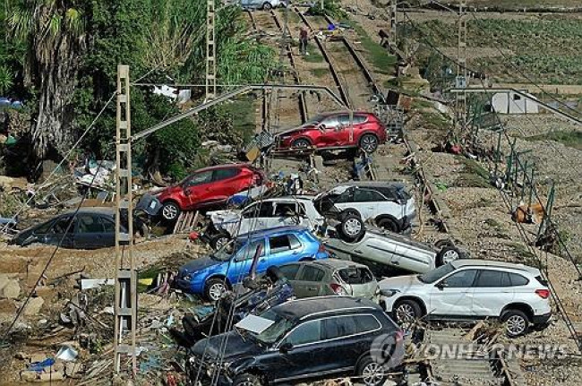 급류에 휩쓸린 차들이 철로 위에 널브러져 있다.