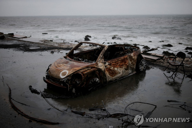 산불에 탄 차량이 폭우로 바닷가에 떠내려온 모습 