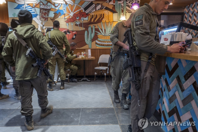개인화기 소총을 메고 카페를 찾은 이스라엘 군인들