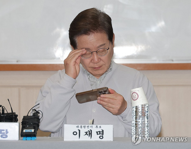 휴대전화 보는 이재명 후보