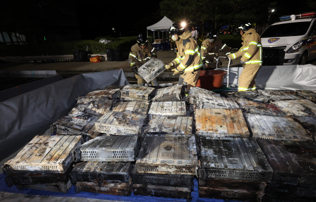 불에 탄 리튬이온 배터리 옮기는 소방대원들